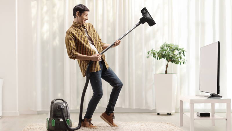 Een man stofzuigt tijdens het dansen.